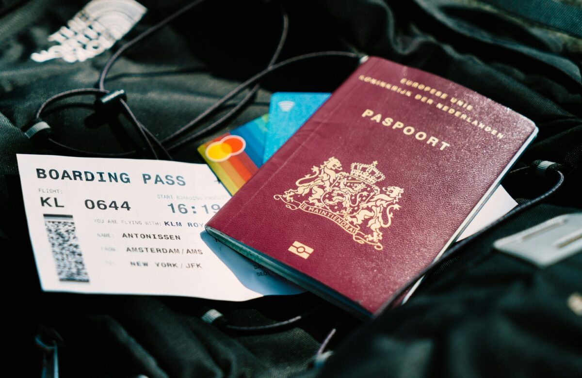 Travel hacking essentials: a boarding pass, travel rewards credit cards, and passport arranged on a backpack, illustrating tools for earning free flights