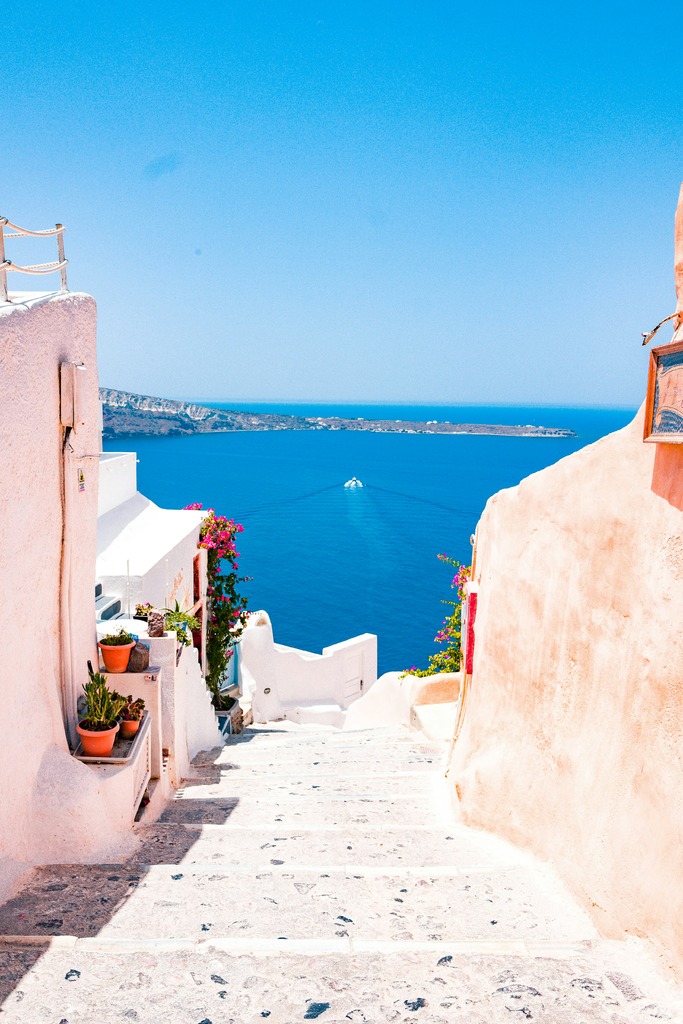 Travel hacking rewards can take you to scenic destinations like Santorini's white pathways and Mediterranean views