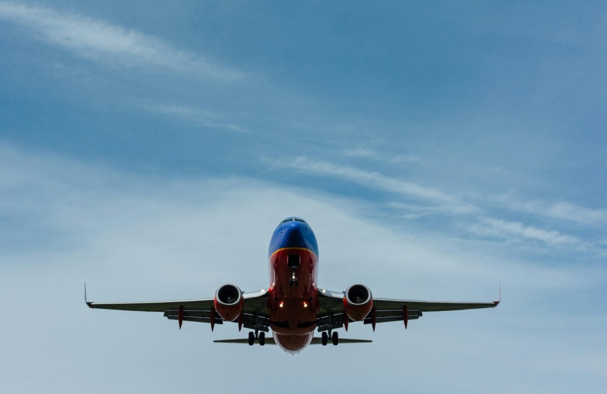 Southwest Airlines plane flying against clear blue sky with travel credit card