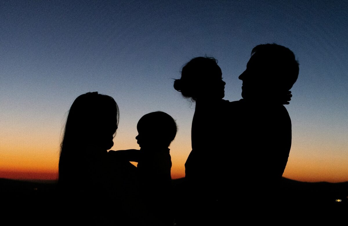 Family silhouette at sunset planning their next travel rewards vacation